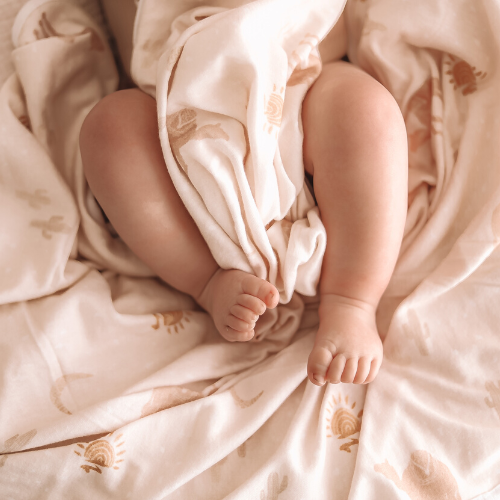Baby toes wrapped in boho beige swaddle blanket